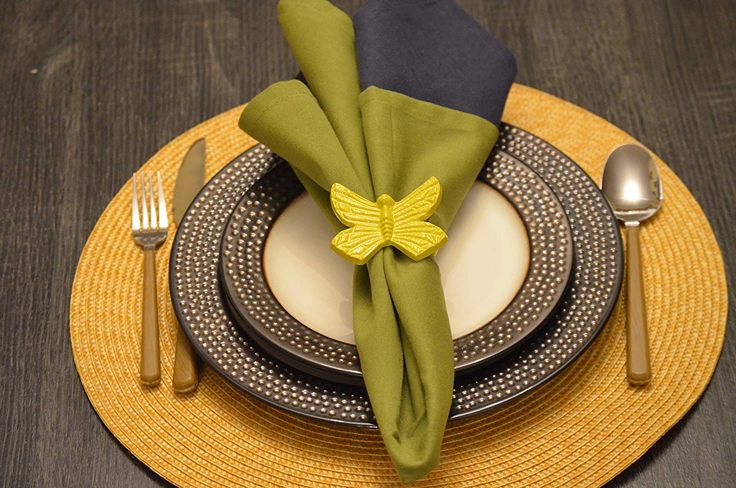 Set of 4 yellow butterfly napkin rings hand-painted on aluminum displayed on a table