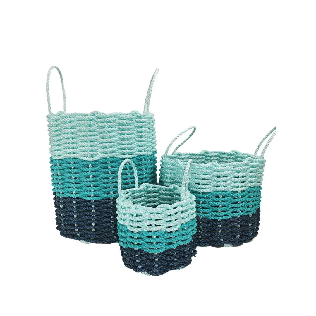 Handmade lobster rope storage baskets in navy blue, teal, and seafoam colors in three sizes