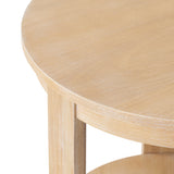 Close-up of a round wood side table with a smooth, light natural wood finish and a supporting leg section visible beneath the tabletop.