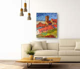Impressionist-style painting of a village with red rooftops and a tower under a blue sky, hung above a beige sofa in a modern living room.