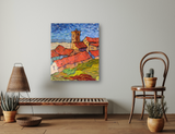 Colorful abstract painting of a town with red rooftops, a tall beige tower, green foreground, and a blue sky with textured brushstrokes, hanging above a wooden bench.