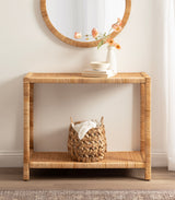 Rectangular console table and round wall mirror, both with natural rattan texture, styled with a white vase holding peach flowers and a woven basket beneath.