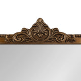 Top section of an arched wall mirror with an ornate bronze-colored frame featuring a symmetrical leaf and scroll design.