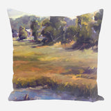 Square pillow featuring an impressionistic landscape with green and golden field, dense trees, and soft purple-blue shadows under a pale sky.