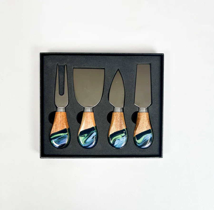 Set of four resin dipped cheese knives with wooden handles in a black box on a white background