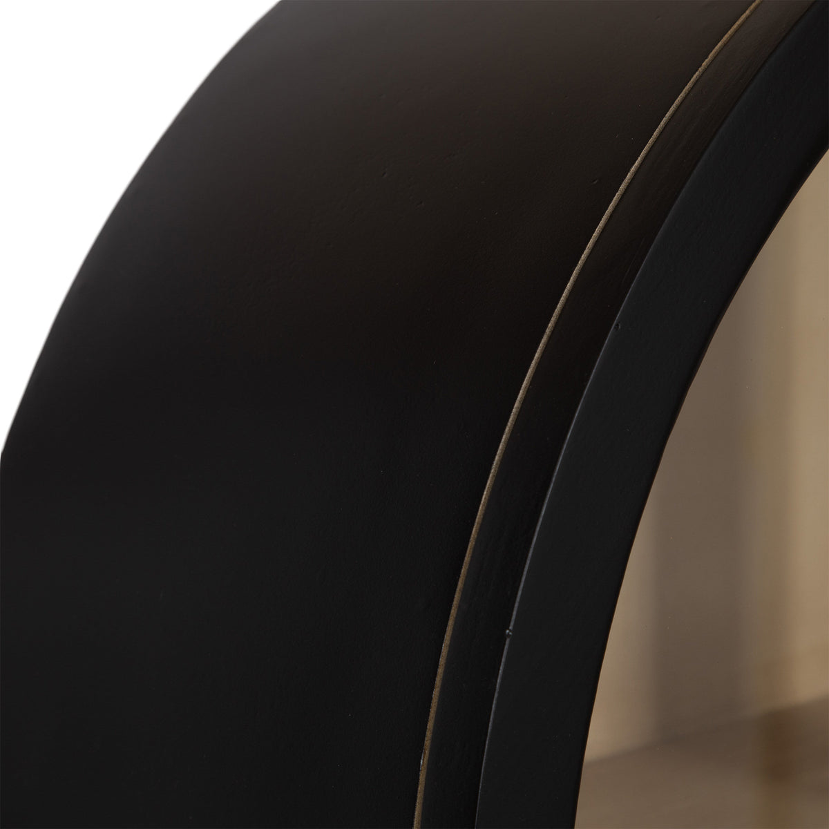 Close-up of a smooth, curved black arch detail on a wall cabinet, highlighting its sleek matte finish and subtle edge contouring.
