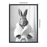 Cute rabbit wearing a white bathrobe, standing upright with ears up, in a black frame with white curtain background showing 18x24 inch dimensions.