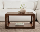 Rectangular walnut wood coffee table with rounded edges and an open bottom shelf, styled with a beige vase holding a small green plant and a small bowl on top.