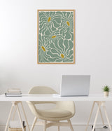 Framed canvas with abstract floral design featuring fluid, teal-colored petals outlined in white and mustard yellow centers, hanging on a white wall above a minimalist desk setup.