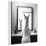 Black and white photo of a llama facing a bathroom mirror, reflecting its front view, with small potted plants and a light switch on the countertop.
