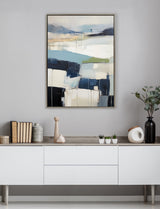 Abstract painting with layered blocks of blue, white, and beige tones accented by thin black lines, framed and hanging above a modern white sideboard with decorative objects.