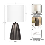 Table lamp with a matte gunmetal scalloped metal base and a soft white linen cylindrical shade measuring 8 inches in diameter and height.