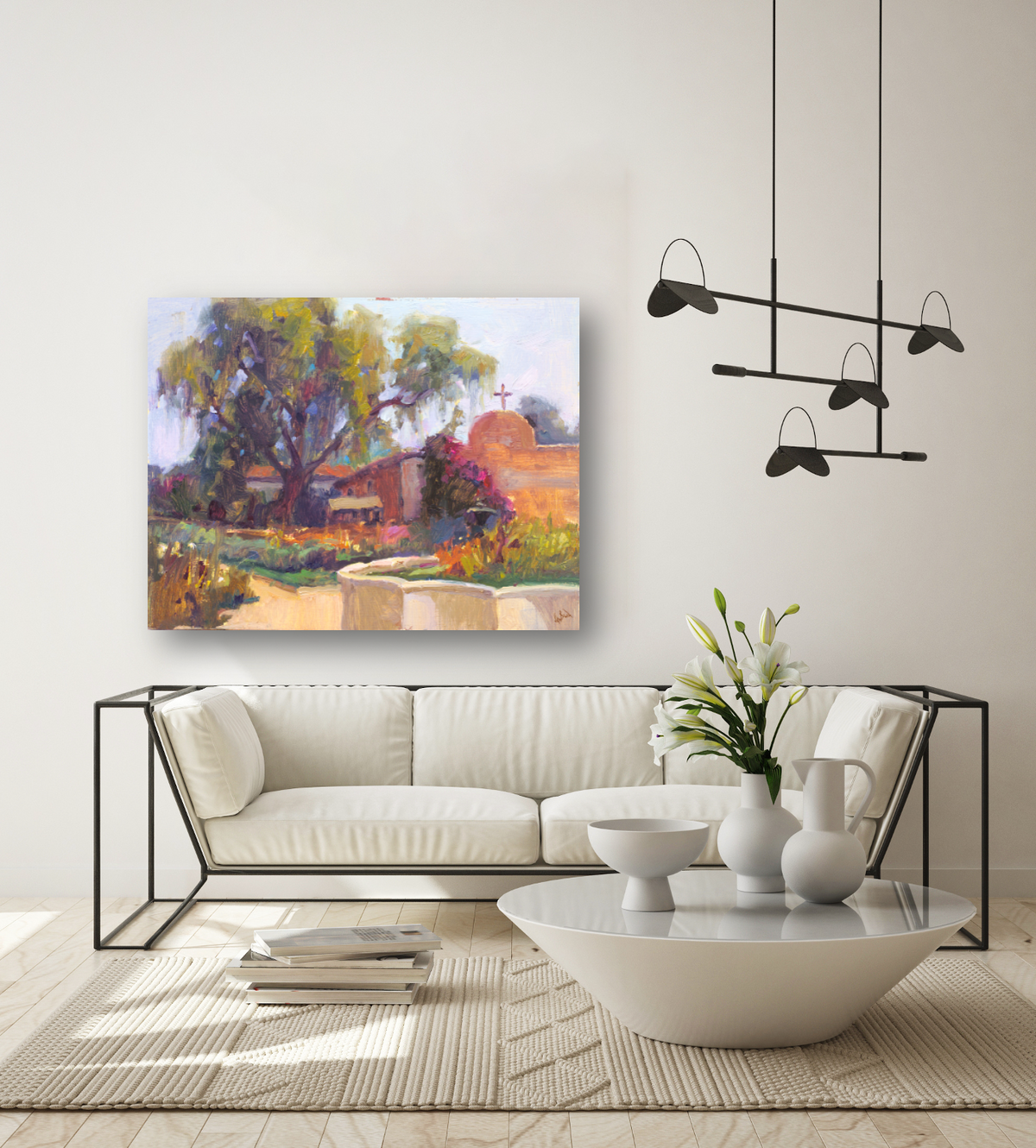 Living room with a modern white sofa featuring black metal frame, a white triangular coffee table with vases and flowers, and a colorful impressionist landscape painting on the wall.