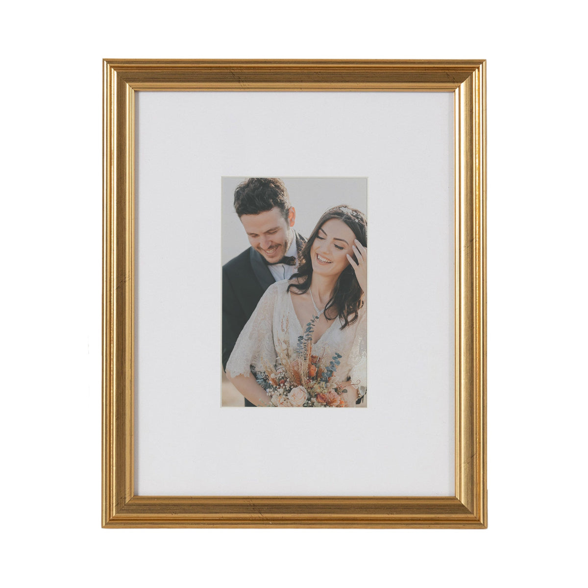 Rectangular wall picture frame with a gold-tone molded border and white mat showcasing a portrait of a smiling couple holding a floral bouquet.