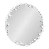 Round wall mirror with a white metal frame featuring delicate floral and leaf motifs arranged asymmetrically around the top left and bottom right edges.