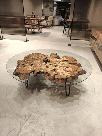 Olive wood rustic coffee table with clear glass top and stone-inspired wooden legs