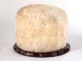 Sheepskin Swivel Pouf Seat with plush white fur and walnut wood base