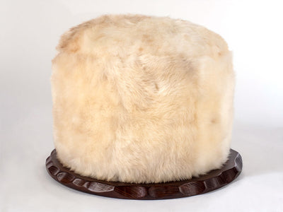 Sheepskin Swivel Pouf Seat with plush white fur and walnut wood base
