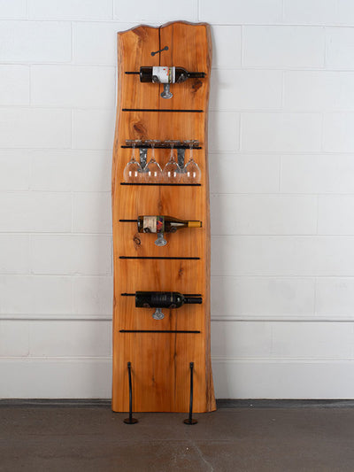 Vertical wine rack made from live edge Redwood with steel legs and shelves holding wine bottles and glasses.