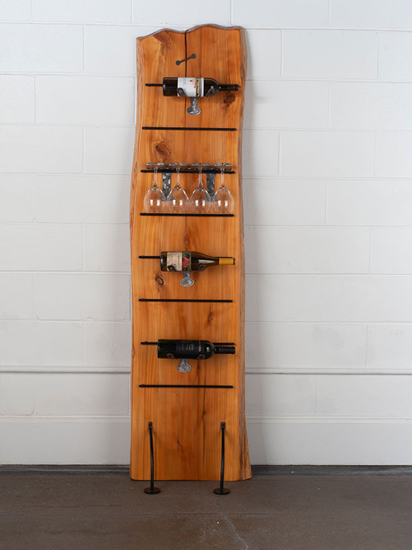 Vertical wine rack made from live edge Redwood with steel legs and shelves holding wine bottles and glasses.