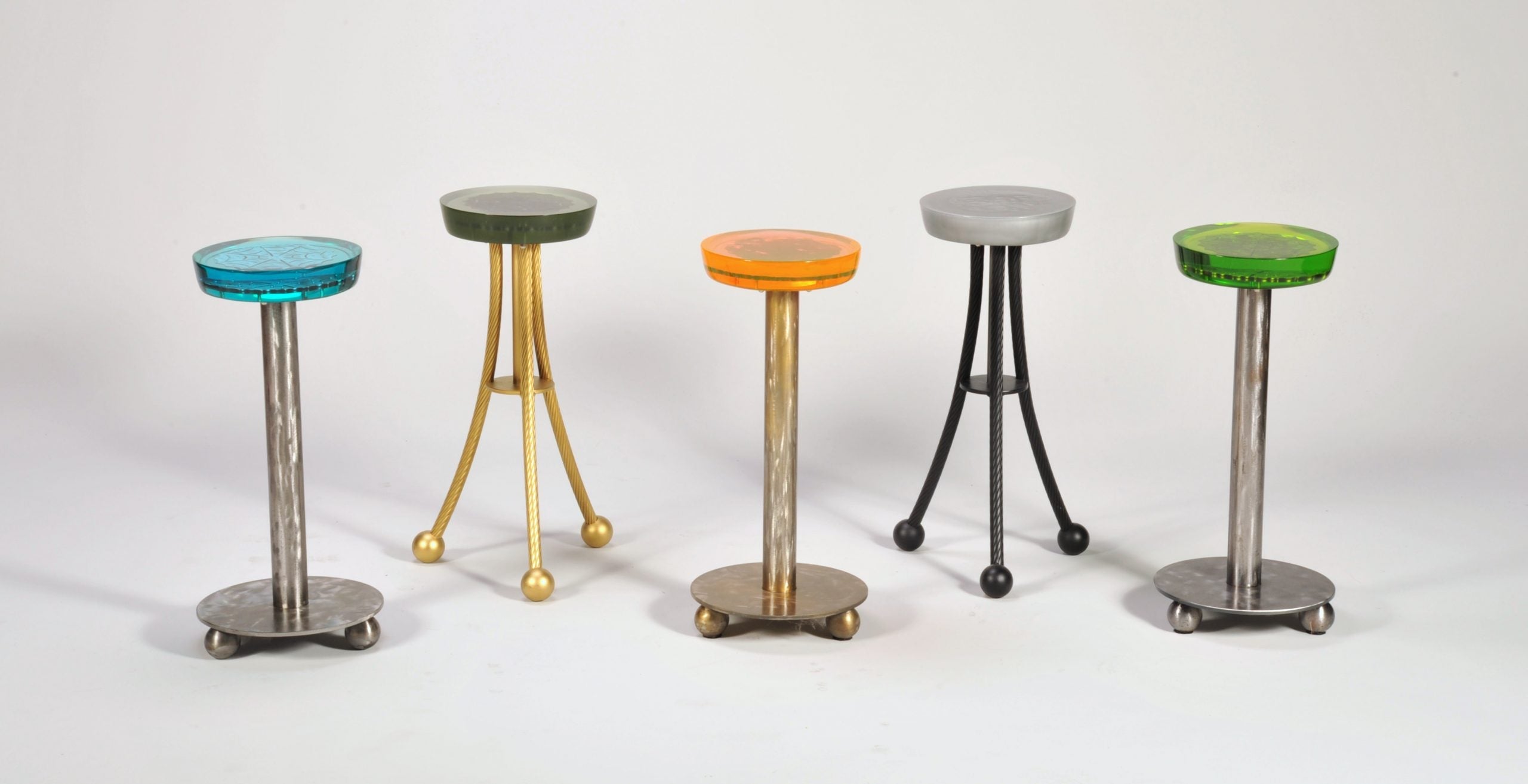 Colorful Enrico Bartolini Martini Tables with epoxy tops and metal inserts in a lounge setting