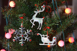 Set of three handmade Christmas ornaments: snowflake, Santa sleigh, and reindeer decorated with red ruby crystals