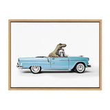 Framed artwork showing a green dinosaur toy driving a sky blue 1958 convertible car model against a white background.