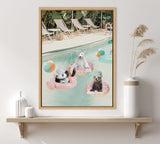 A framed canvas print showing three animals—a panda, polar bear, and brown bear cub—floating in pool tubes shaped like flamingo and donuts, near colorful beach balls and lounge chairs by a poolside.