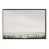 Framed canvas depicting a tranquil beach view with soft pale sky, ocean waves, sandy shore, and grassy dune fencing in muted natural tones.