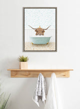 Framed canvas of a brown Highland cow with long curved horns peeking from a pale blue clawfoot bathtub, a small yellow duckling perched on its head, beach tile floor and fish pattern wallpaper background.