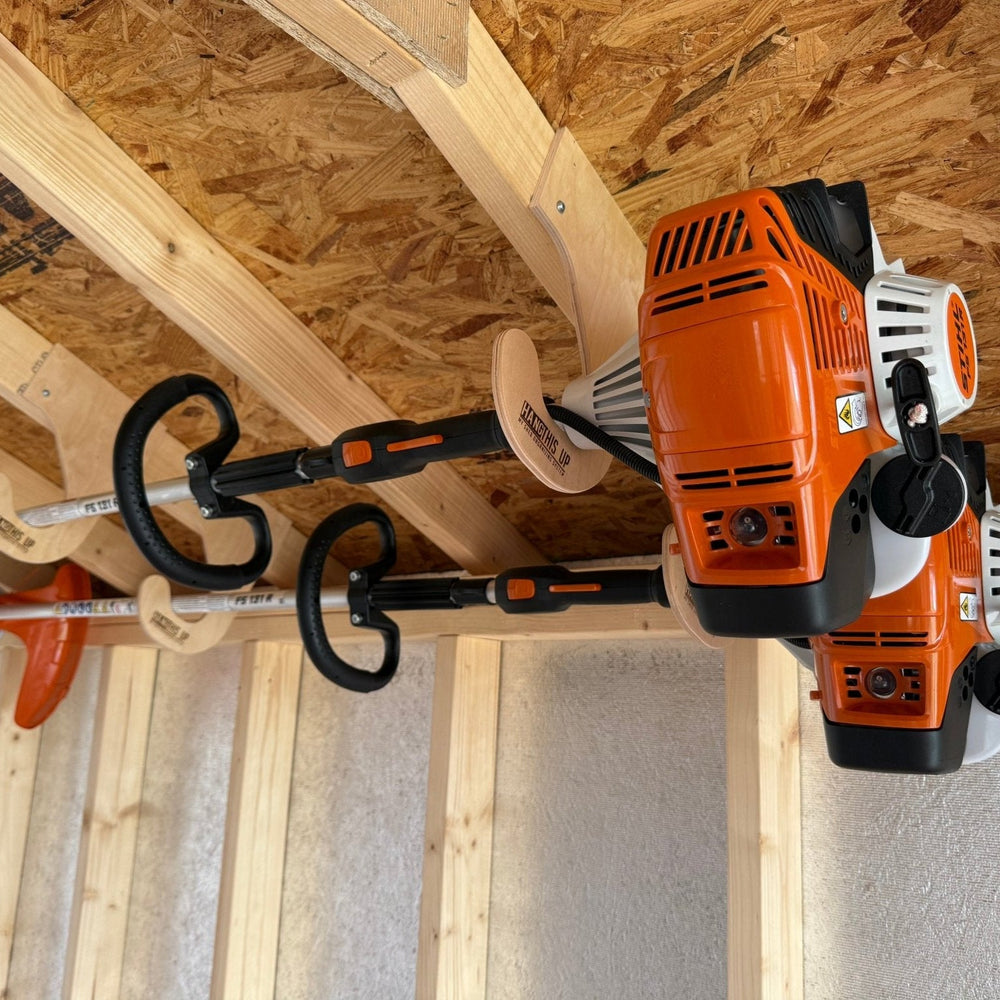 Ceiling mounted weed wacker rack installed in a shed holding weed eaters