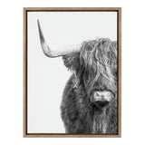 Black and white portrait of a Highland cow with long shaggy hair covering its eyes and a prominent left horn, framed in light wood against a white background.