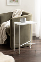 Minimalist white metal Sanzo Slim Side Table with rectangular top and slender legs, next to olive green curved armchair draped with chunky knit blanket
