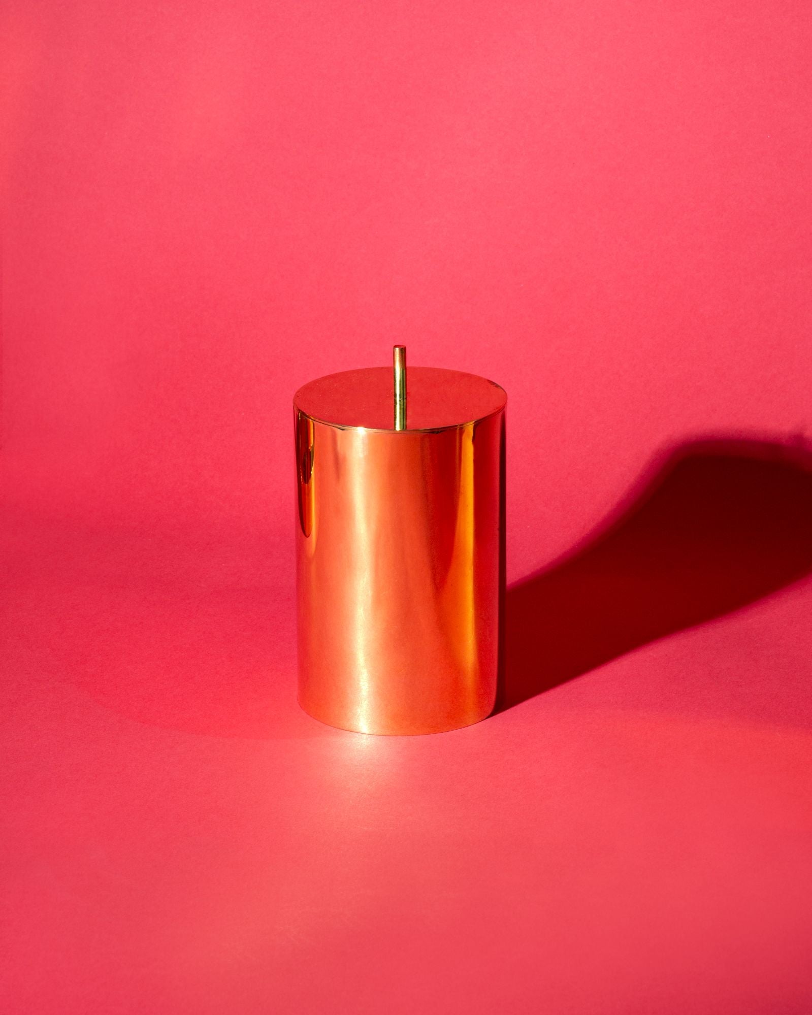 Paavo Canister in polished brass on a wooden surface