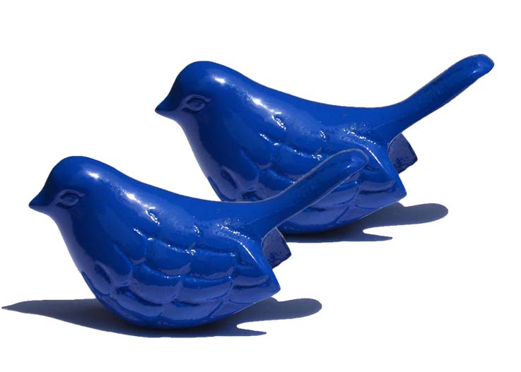 Two small blue bird figurines with raised feather details and smooth glossy finish casting shadows on a white background, showing one larger and one smaller bird.