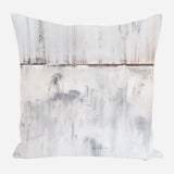 Square pillow with abstract white and gray vertical streaks resembling weathered wooden panels, featuring subtle rust and charcoal accents.
