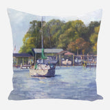 Pillow featuring a painted scene of a white sailboat with green sails on calm water near docks and lush trees in soft, impressionistic colors.