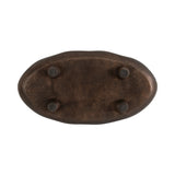Oval dark brown decorative tray seen from the bottom showing four rounded feet and a slightly textured surface