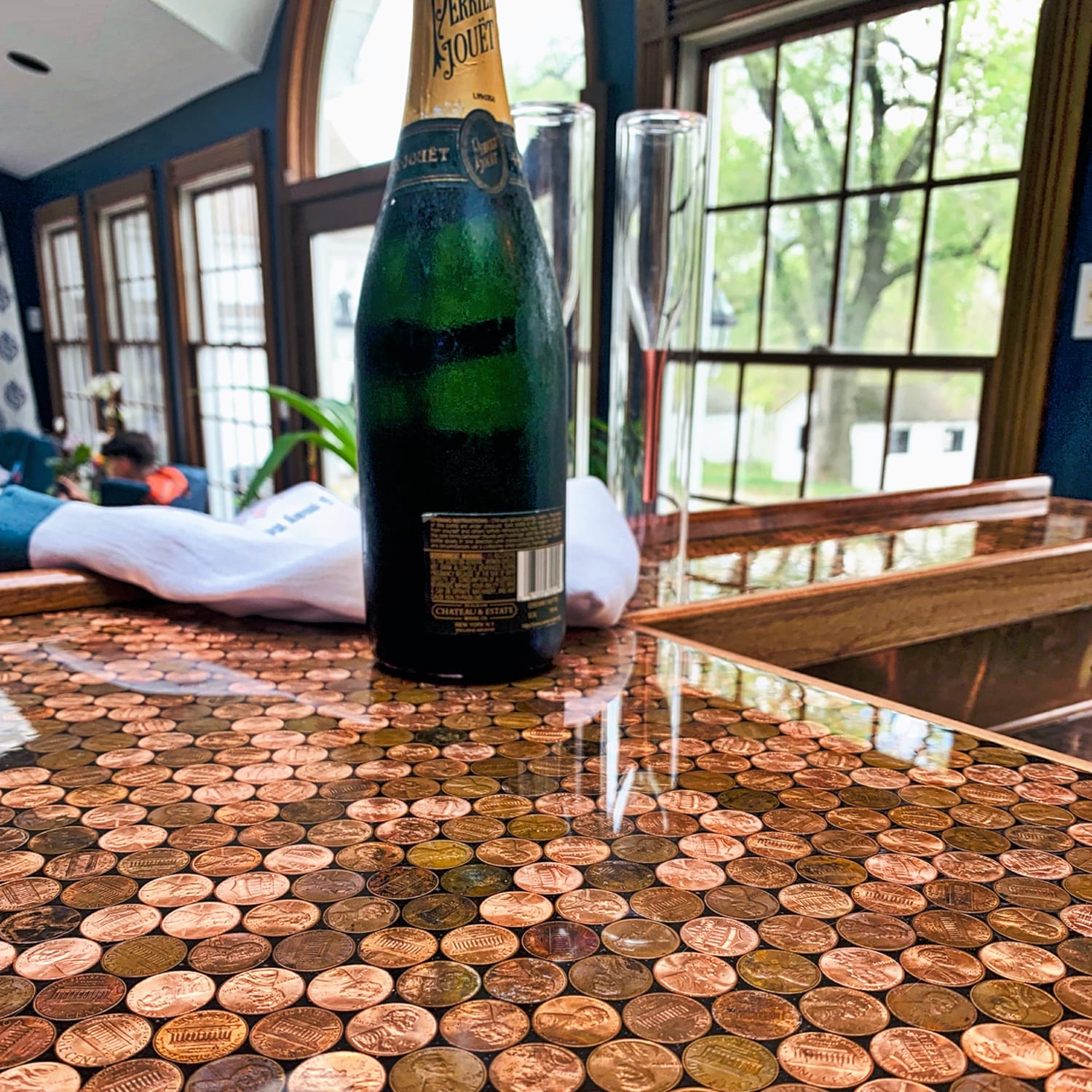 Bottle of Perrier Jouet champagne on a table with a unique penny surface