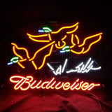 Neon sign with two orange flying ducks featuring green and blue accents above cursive red Budweiser text on a dark background.