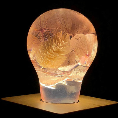 Three handcrafted flower-shaped resin LED bulbs in a 3-pack