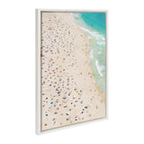 Aerial view of a crowded sandy beach with colorful umbrellas scattered across the shore and turquoise waves breaking along the coastline.