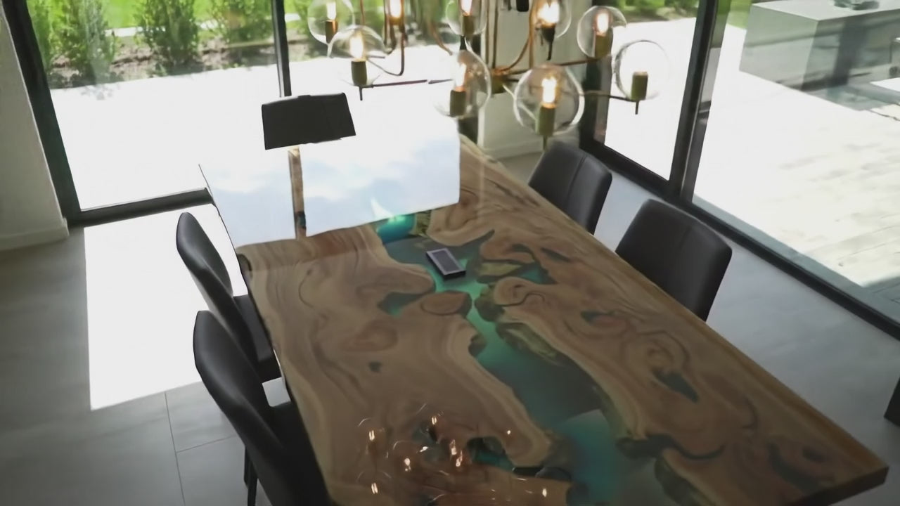 Load video: Epoxy Resin Dining Table Video Pan View Over Across The Table Showcasing The Blue Epoxy Resin River in between two walnut slabs of the finished dining table