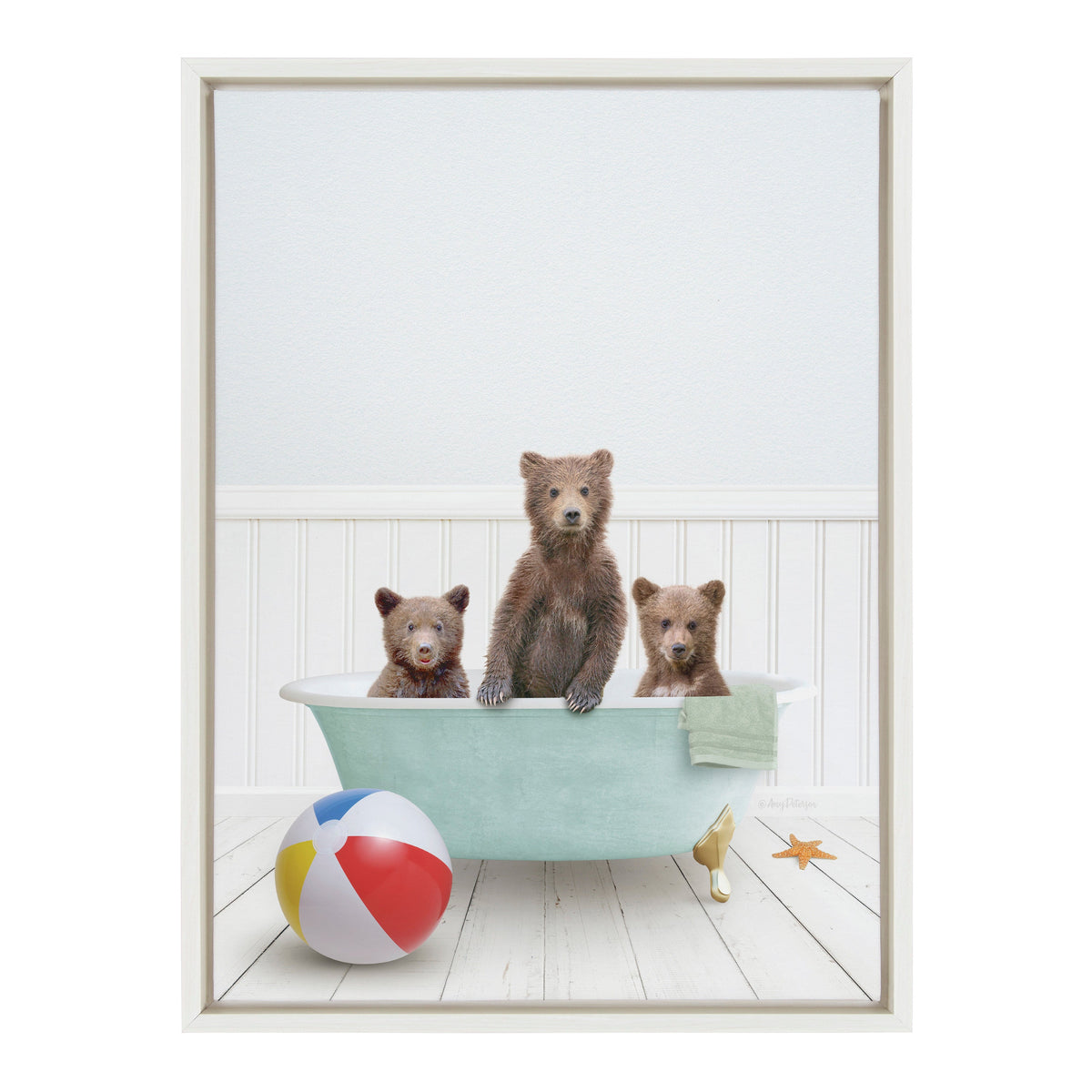 Three brown bear cubs sitting in a light blue clawfoot bathtub on white wooden floor with beach ball and starfish nearby, against a white paneled wall.