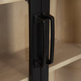 Close-up of dual black metal handles on a glass door, revealing light wood interior shelves in the background of a cabinet.
