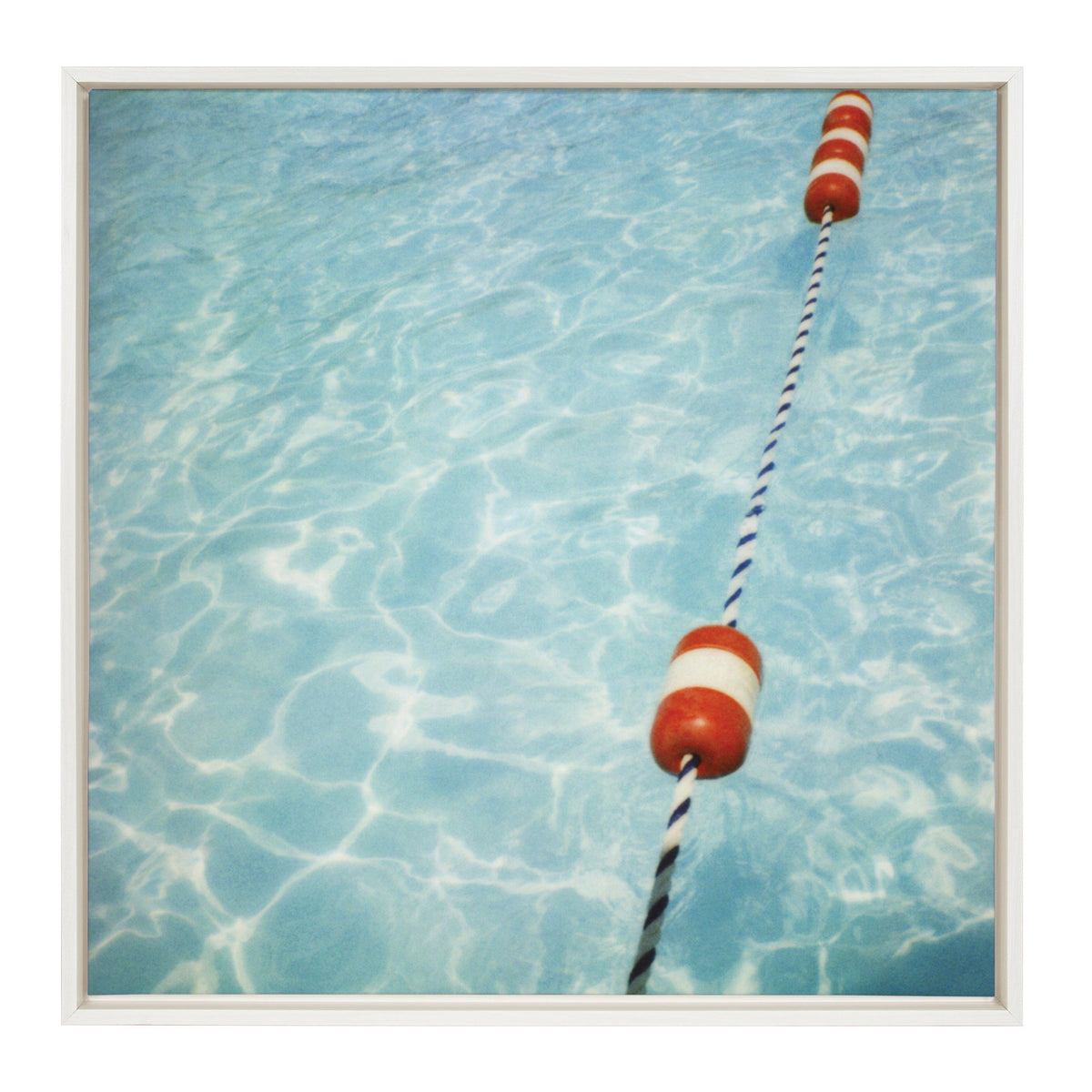Framed canvas print of a pool's clear blue water surface with rippling light reflections and a diagonal blue-and-white rope with red-and-white floaters.