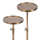 Two round polished metal tables with adjustable height, featuring warm bronze tones and butterfly screw clamps on slender central stems.