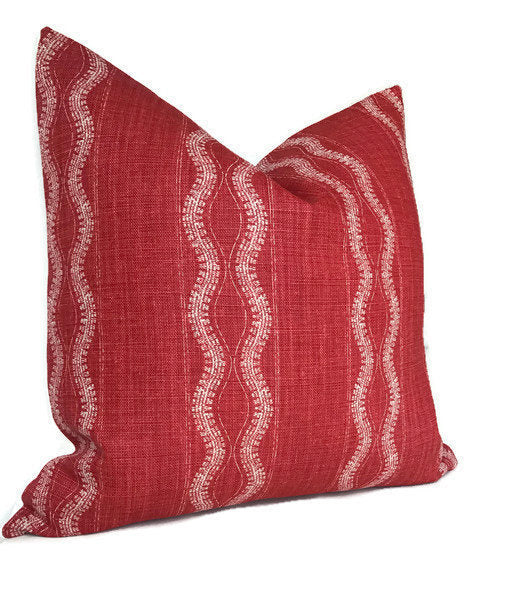 Square red linen pillow cover with vertical wavy white stripes pattern, slightly textured fabric and a soft, plush appearance.