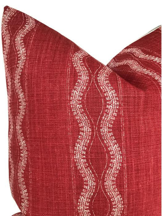 Close-up of a red Zanzibar pillow cover with wavy light beige stripes running vertically, showing textured woven fabric and neat corner seams.