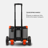 Rear view of a gray and orange portable power station with a black telescoping handle extended and large rugged wheels for transport.